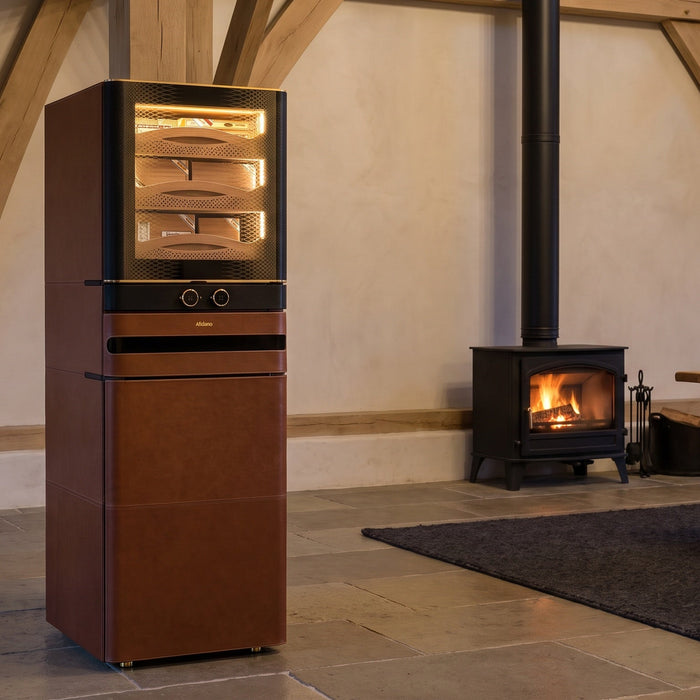 Afidano L8 2200-count leather cigar humidor cabinet in a converted barn great room beside a wood-burning stove
