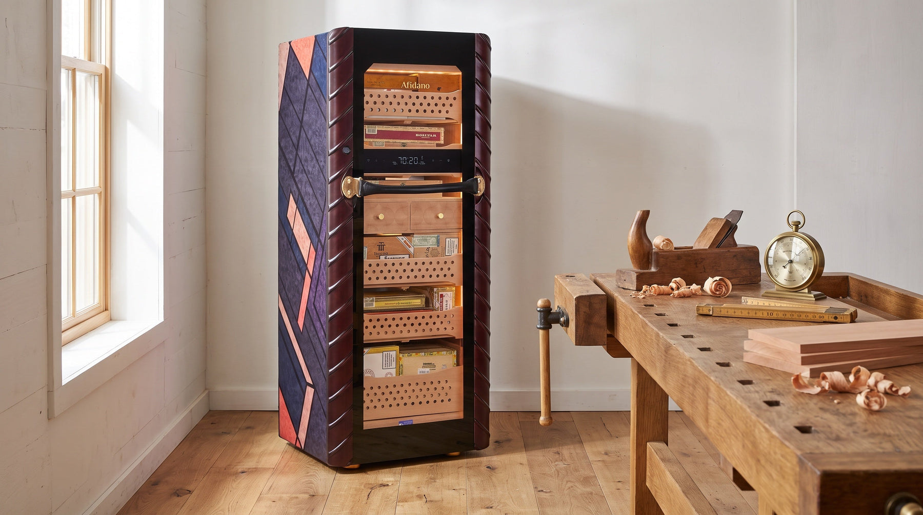Afidano C5 Atelier cigar humidor with marquetry side panel in a cabinetmaker's workshop beside a workbench