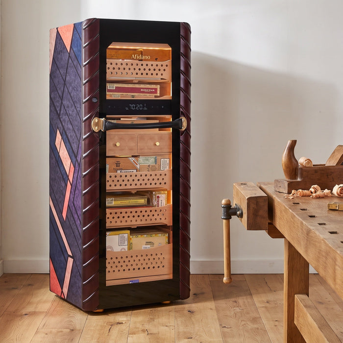 Afidano C5 Atelier cigar humidor with marquetry side panel in a cabinetmaker's workshop beside a workbench
