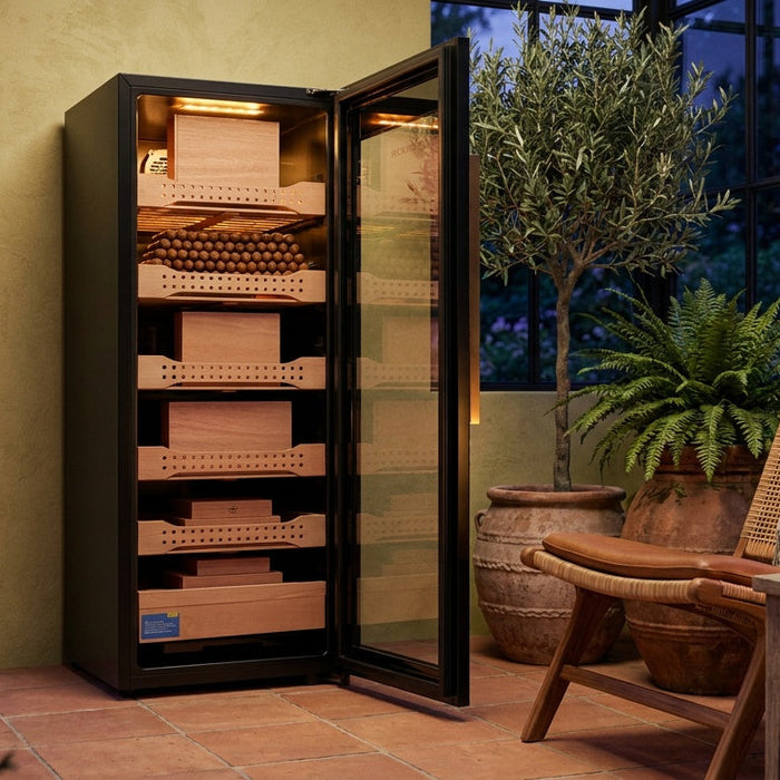 Afidano B4 steel cigar humidor cabinet open in a conservatory, lit Spanish cedar trays of cigars and cedar boxes
