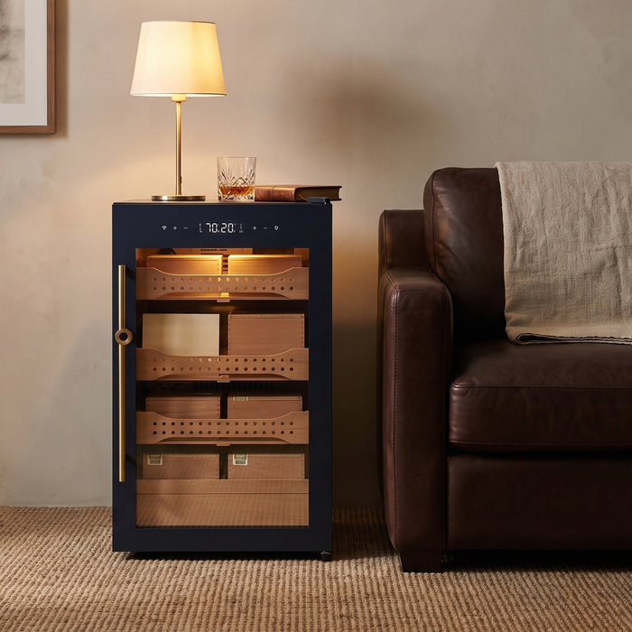 Afidano B2 cigar humidor cabinet used as an end table beside a leather sofa, brass lamp standing on its top