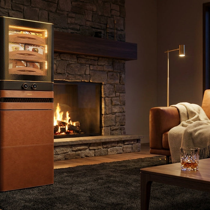 Afidano L8 Artistry cigar humidor cabinet in cognac leather beside a fireplace, lit Spanish cedar shelves on display