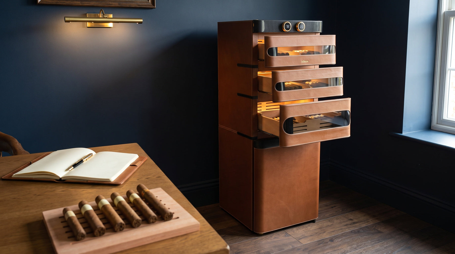 Afidano L5 leather cigar humidor with three drawers open beside a desk with cigars sorted by size and a notebook