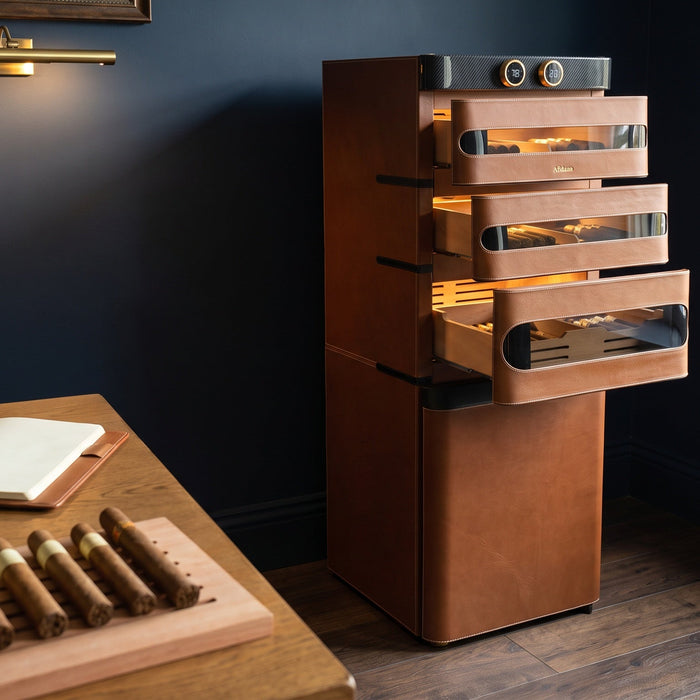 Afidano L5 leather cigar humidor with three drawers open beside a desk with cigars sorted by size and a notebook