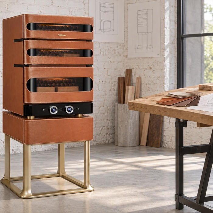 Afidano L3 Artistry leather cigar humidor on its gold stand in a sunlit industrial designer's studio